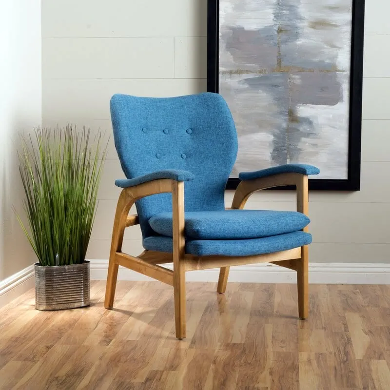 Interior inspiration — blue upholstered mid-century armchair with a wood frame beside a potted plant