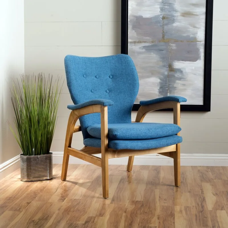 Interior inspiration — blue upholstered mid-century armchair with a wood frame beside a potted plant