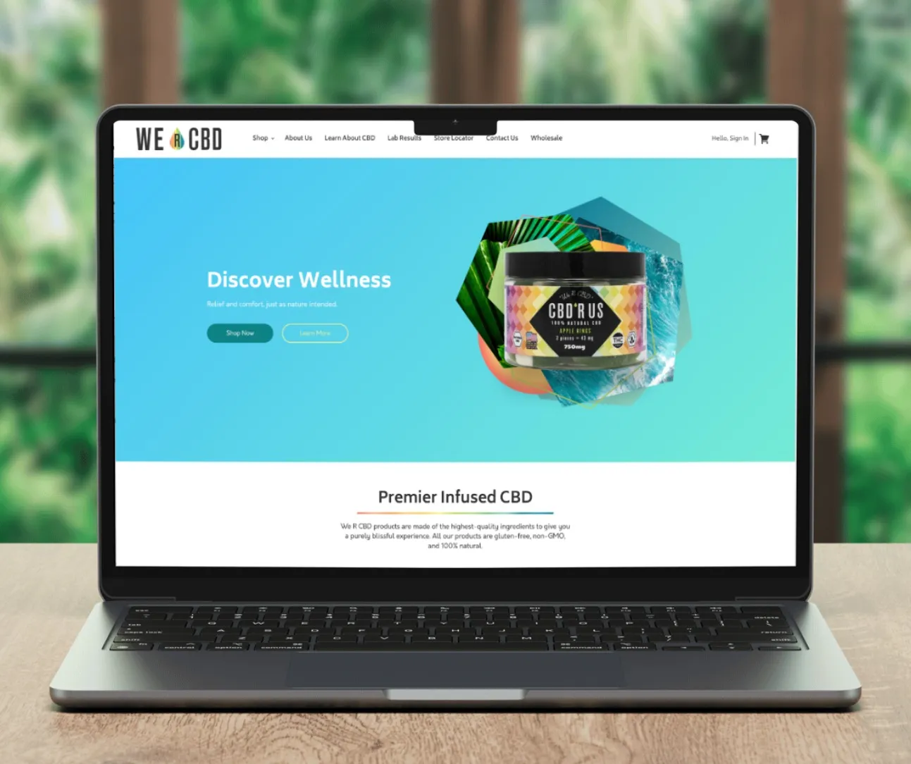 Laptop mockup of the We R CBD homepage with a 'Discover Wellness' hero, product jar and 'Premier Infused CBD' section