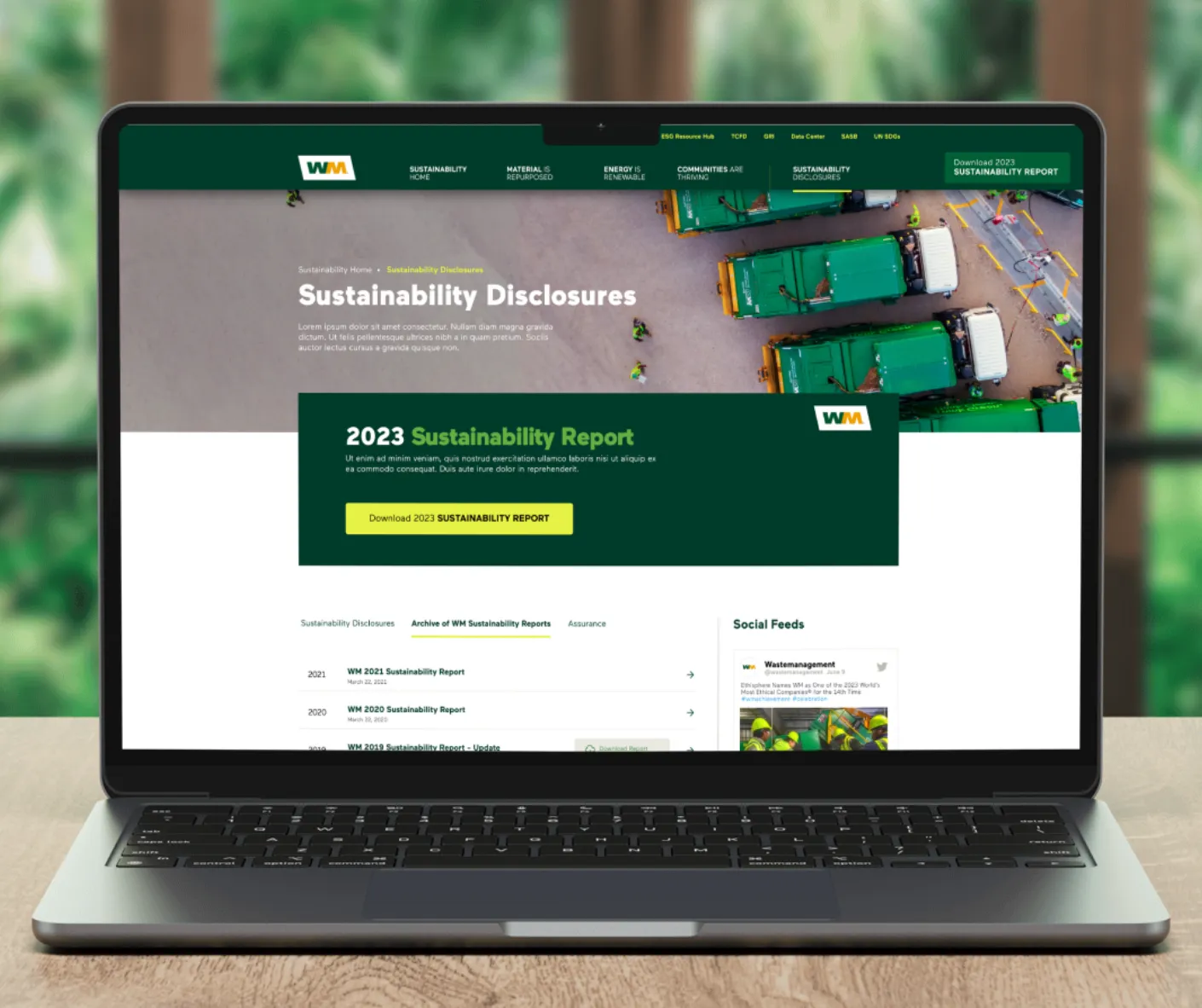 Laptop mockup of WM Sustainability Disclosures page promoting the 2023 Sustainability Report over an aerial trucks photo